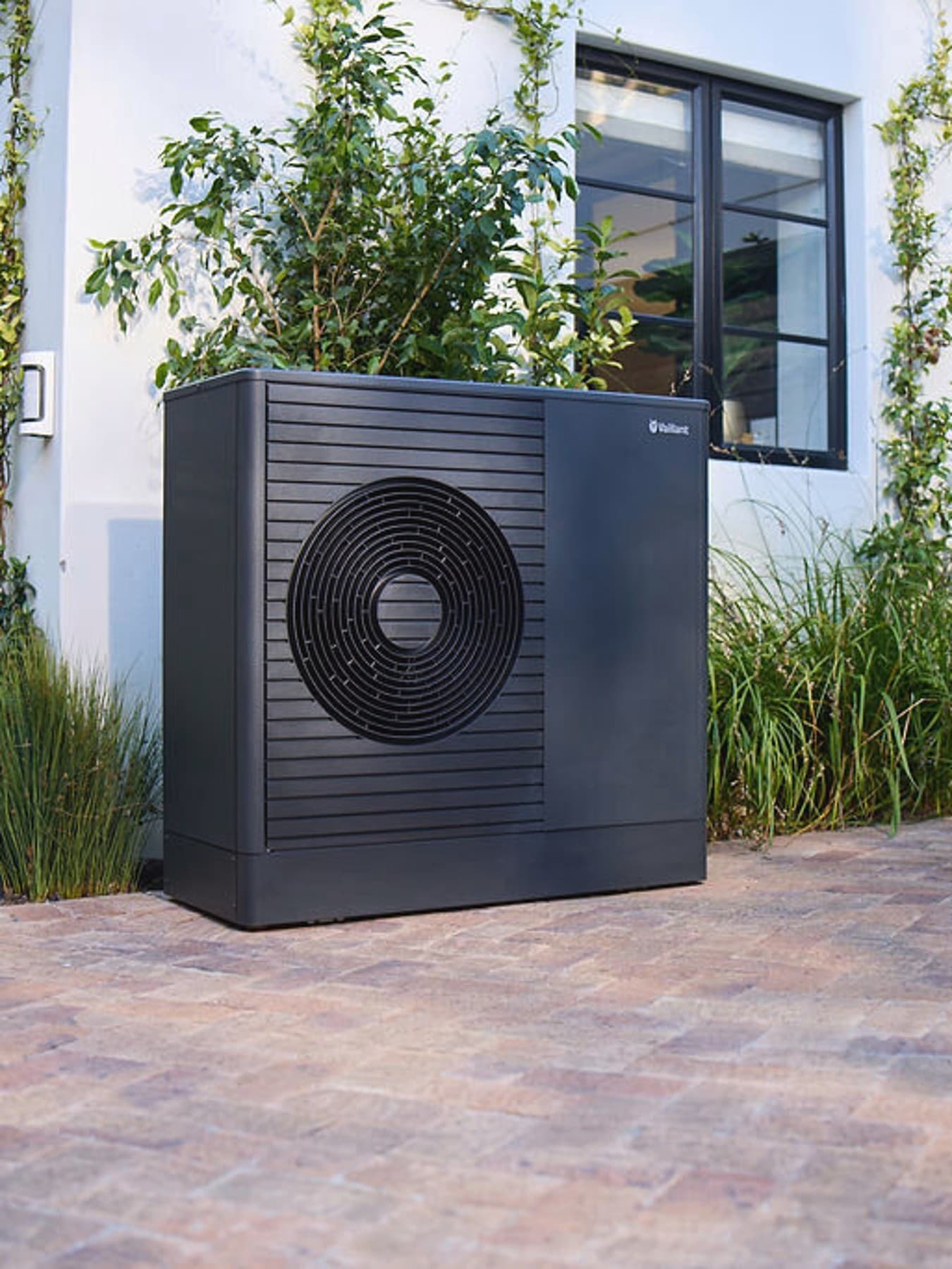 Тепловий насос Dark Vaillant aroTHERM plus у передньому саду будинку